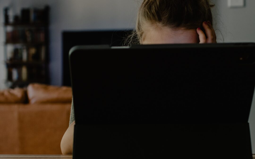 woman in white tank top sitting on chair using black laptop computer thinking I don't want to work anymore